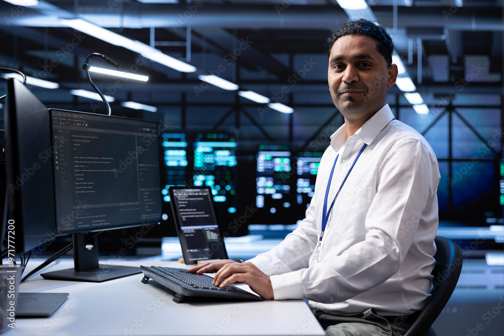 Poster portrait of smiling engineer checking event logs on computer to find out of order data center electr