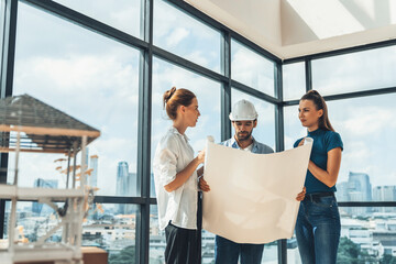 Fototapeta premium Group of architect engineer looking at project plan while brainstorming idea about building structure. Manager team discuss about building construction while standing near with city view. Tracery.