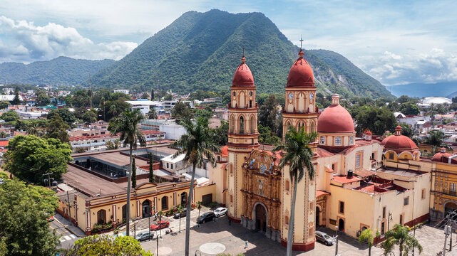 Orizaba, Veracruz, Mexico - July 14, 2022: Surrounded by mountains, cloudy sun shines on the historic core and churches of downtown Orizaba.