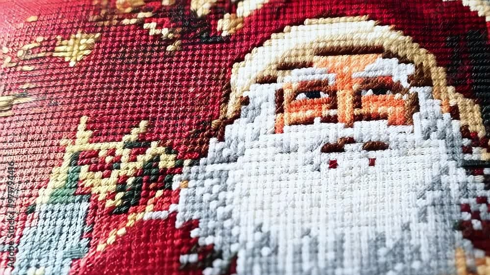 Poster creating a festive atmosphere with a needlepoint of santa claus on red canvas, adding a touch of han