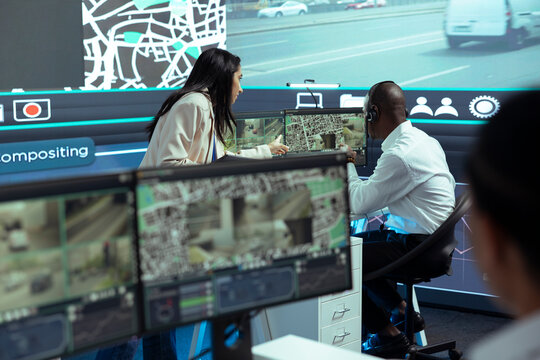 Indian team leader offers order logistics insight to her team in monitoring room, working on express delivery service. Employee consulting his manager about gps tracking intelligence.