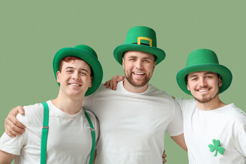 Happy young men in leprechaun's hats hugging on green background. St. Patrick's Day celebration