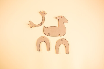Brown cardboard pieces arranged for reindeer craft, including body, head, and legs. Ideal for showcasing recycled paper use in creative, eco friendly projects,