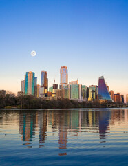 Austin Texas skyline buildings seen at sunset with full moon and Lady Bird River.