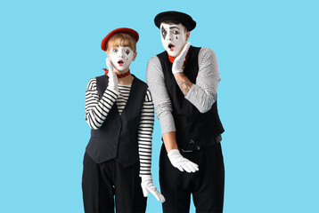 Couple of surprised pantomimists on blue background