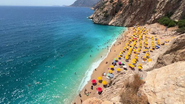 Antalya, August 2024: People sunbathe and swim on Kaputas beach in Turkey on the Mediterranean coast. A beach with clear turquoise waters of the sea, between the towns of Kash and Kalkan. 4K