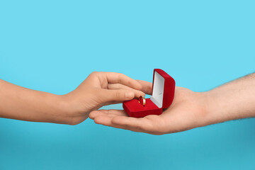 Young man proposing to his girlfriend on blue background