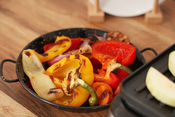 Tasty grilled vegetables in bowl on wooden table, closeup