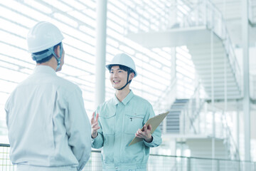 現場で打ち合わせをするヘルメットを着用した作業員