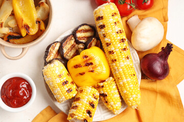 Plate with grilled vegetables, napkin and bowl with sauce on white background