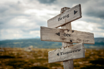 bring on tomorrow text quote on wooden directional signpost outdoors in nature