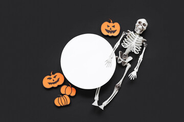 Blank card and Halloween decorations on dark background, top view