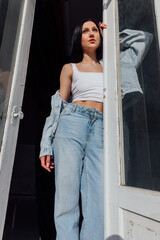 Beautiful fashionable brunette woman in jeans and outdoor t-shirt