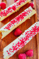 Wafer pastries with sublimated berries. Wafer rolls with butter cream and dried raspberries. Summer Berry Baking. Crispy wafer tube with edible decorations. Crispy sweet dessert. 