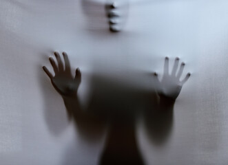 Person, shadow and sheet with ghost for horror, torment or evil spirit on a gray studio background....