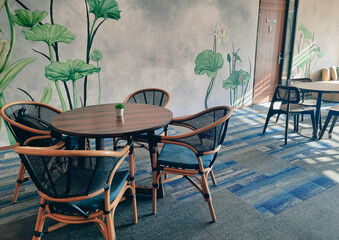 Modern office cafetaria with decorative plant on the wall, warm light with empty chair and table. Office Pantry.