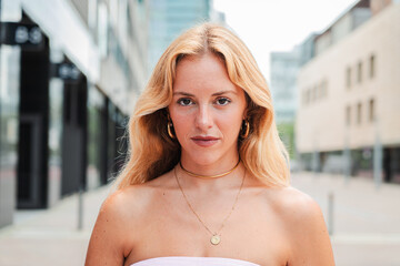 Close-up individual portrait of a serious adult Caucasian woman outdoors looking at the camera. One...