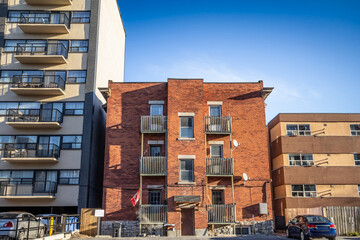 A neglected small apartment building on a residential street in Ottawa, Ontario, during an autumn...