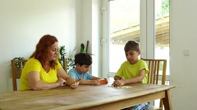 Mother shows kids how to play domino, board game and time together