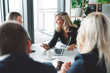 Senior woman director giving instructions to her employees