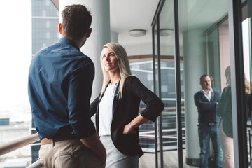 Business couple talking outside on the office balcony