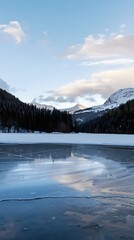 Winter landscape with a frozen lake reflecting snowy trees and mountains, showcasing the calm and stunning beauty of nature