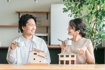 マイホームの計画をする若い夫婦（相談会・ハウスメーカー・家づくり）
