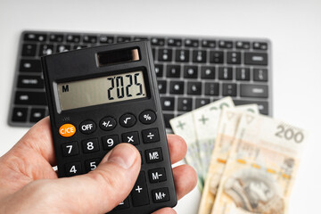 Calculator held in hand with the year 