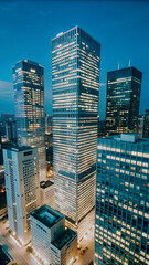 Aerial footage over illuminating cityscape buildings at night