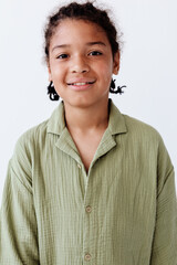 Stylish young boy in green shirt posing against a white background with trendy vibes and confidence