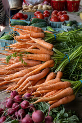 fresh carrots and vegetables on display outdoor market