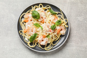 Tasty pasta with shrimps on light grey table, top view