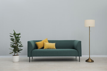 Stylish room interior with comfortable sofa and houseplant
