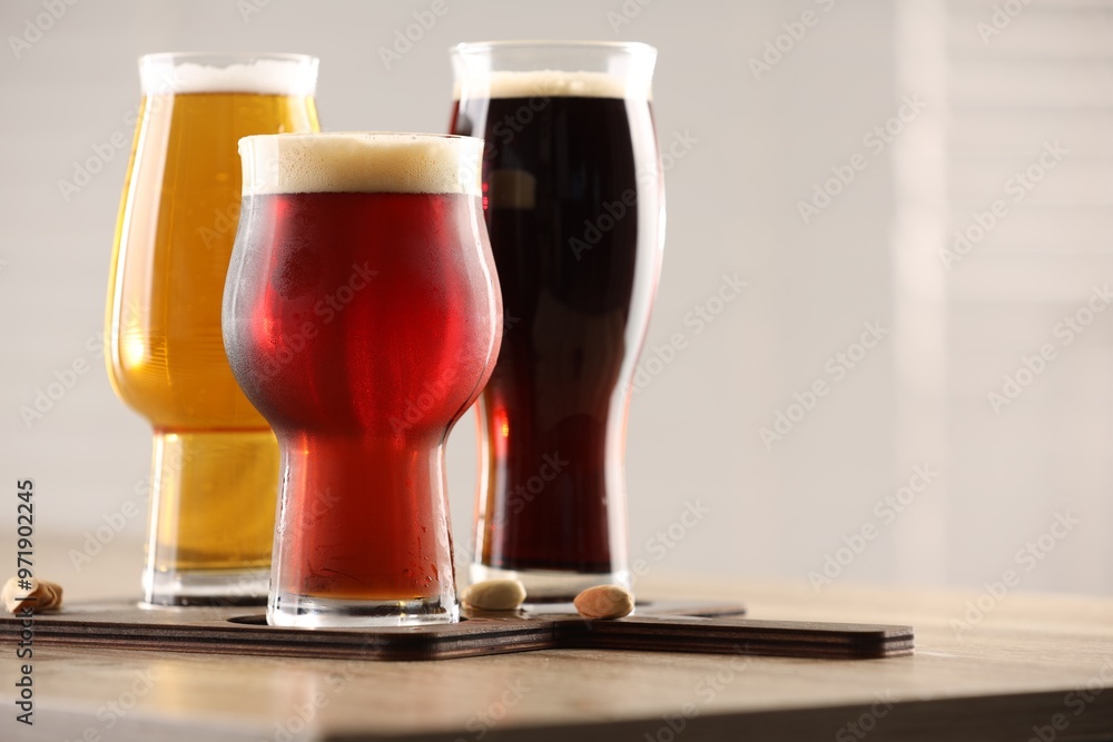 Canvas Prints Glasses with different types of beer on wooden table indoors, closeup. Space for text