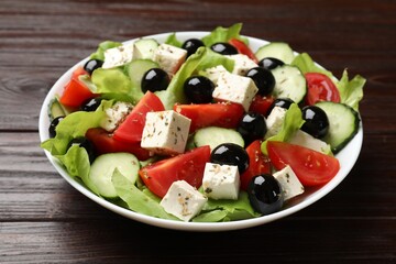 Delicious salad with feta cheese on wooden table, closeup