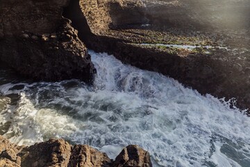 Naklejka premium Waves crashing over rocks at Piha, Auckland, New Zealand.