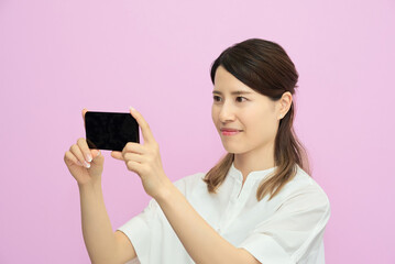 Naklejka premium スマートフォンの画面を見る若い女性