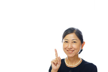 喪服を着て笑顔で指さす中年女性