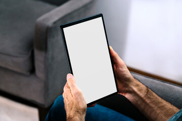 Man holding a tablet computer with blank screen for mockup. White screen for place your design.