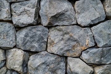 Close-up of a gray stone wall with rough texture and irregular shapes