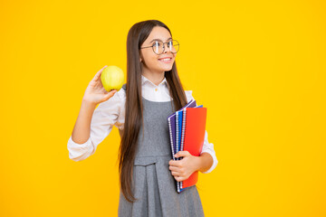 Back to school. Teenager schoolgirl with bag hold apple and book, ready to learn. School children on isolated yellow background.