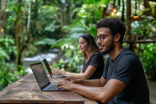 Digital nomads working with laptops in lush nature setting