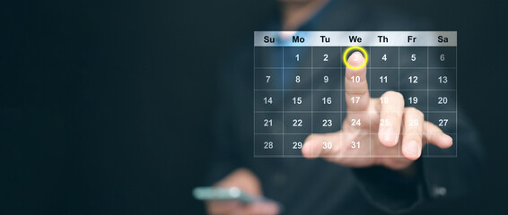 Planning and time management concept. A man manages his time using virtual screen calendar interface to highlight the date to remind him about important work, meeting, or agenda