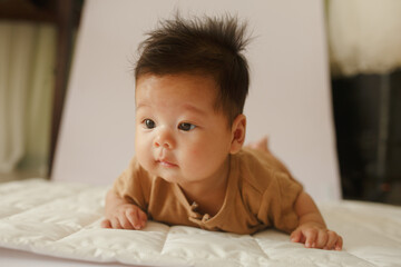 a baby laying on a bed looking at the camera