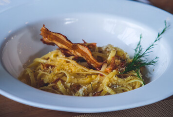 Carbonara with crispy bacon on top.