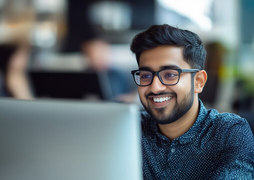 Young South Asian Business Man Smiling at his Computer, Young Man Wearing Glasses Looking at his Laptop