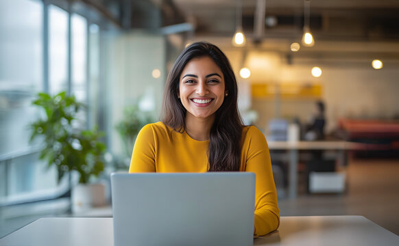 Pretty Young South Asian Woman working on Her Laptop, Young Professional Wearing Yellow in a Modern Office