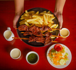 Anticucho Peruano con papas fritas ensalada parrillera