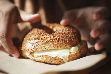 Enjoy a Freshly Made Sesame Bagel with Cream Cheese on a Wooden Board, perfect for any meal