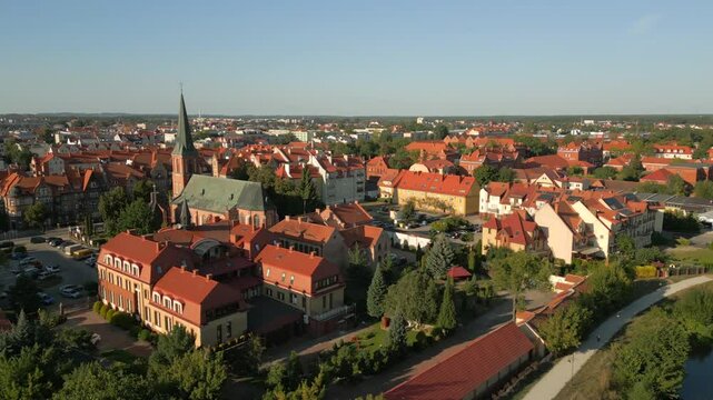 Drone shot reveals beautiful historical gothic city Elk residential apartments, commercial buildings and street view, St. Wojciech Cathedral church building from the back